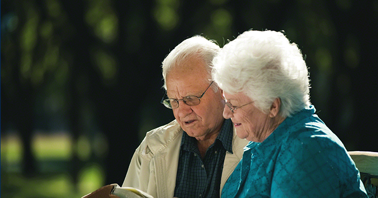 Elderly couple looking at a book